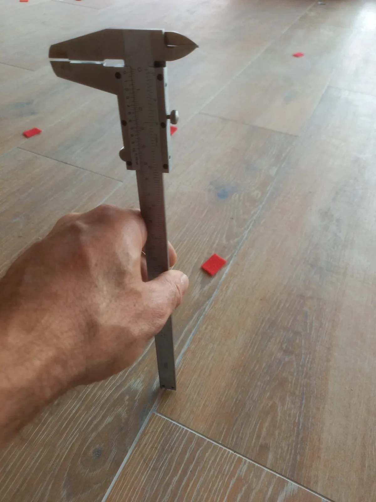 Mesure au pied à coulisse d'un désaffleurement entre deux lames de carrelage